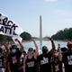 Attendees raise their fists while participating in the March on Washington at the Lincoln Memorial Friday, marking the 57th anniversary of Rev. Martin Luther King Jr.’s “I Have A Dream” speech there.